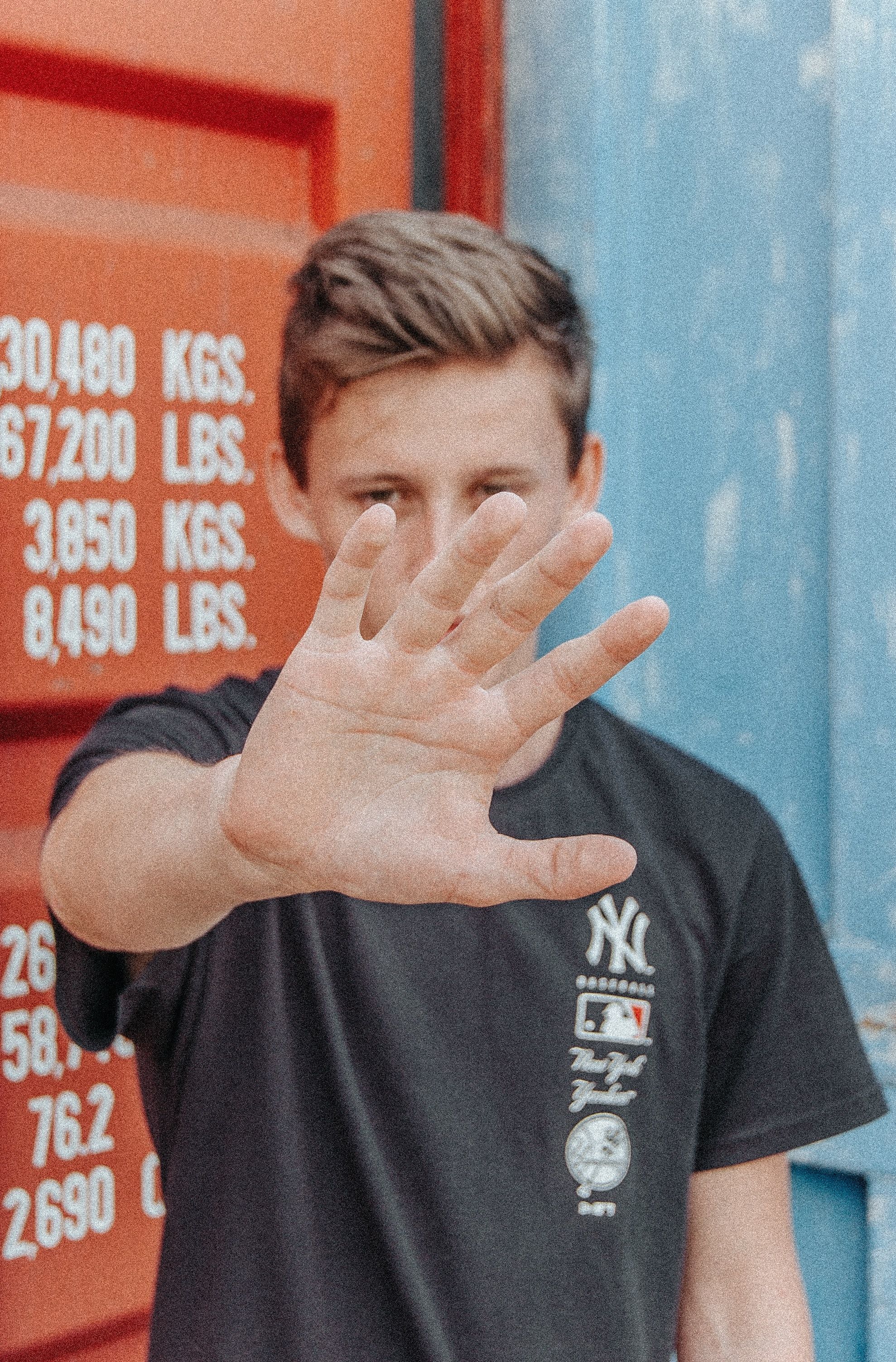  Hand help up to stop, next to a shipping container